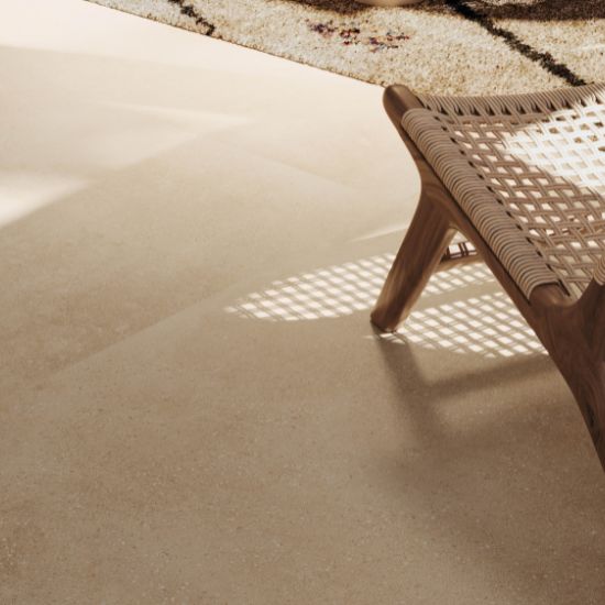 Sala minimalista con piso Venux Bellissima Beige beige veteado, sofá blanco, mesa redonda y luces colgantes en ambiente luminoso