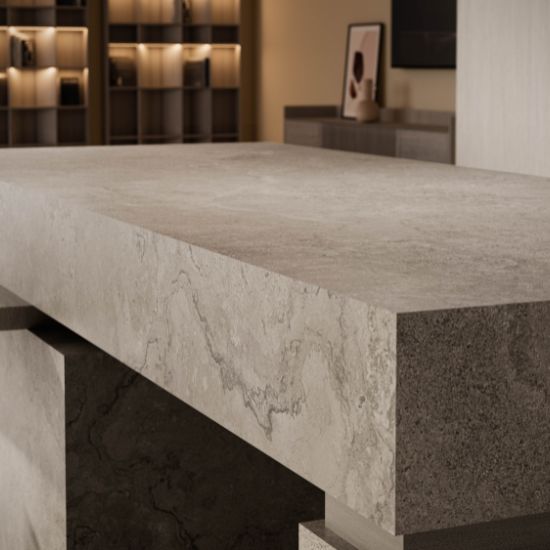 Cocina moderna con isla Venux Bourgogne Perle gris uniforme, taburetes marrones y gabinetes oscuros en ambiente luminoso.