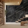Sala moderna con pared Venux Calacatta Black negra veteada, escalera madera, lámpara y sillón en ambiente sereno con suelo beige.