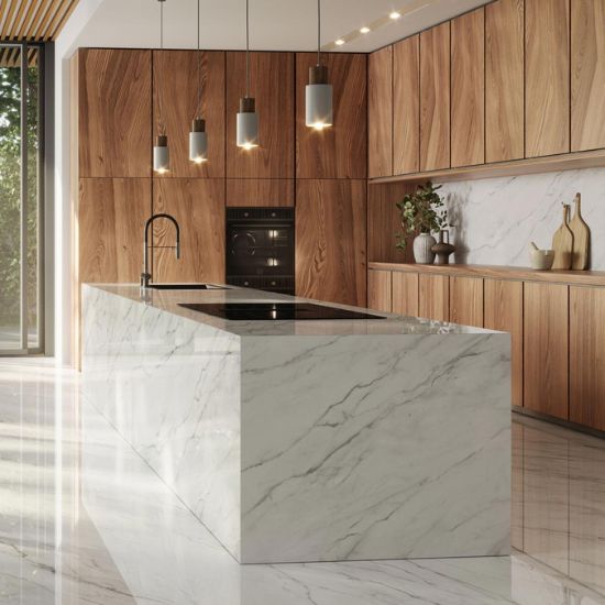 Cocina moderna con isla Venux Calacatta Classic blanca veteado, taburetes madera y gabinetes oscuros en ambiente elegante con vista jardín.