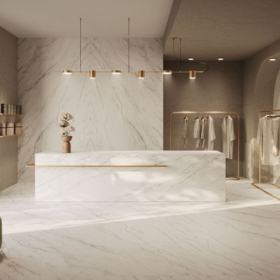 Cocina moderna con isla Venux Calacatta Classic blanca veteada, taburetes madera y gabinetes blancos en ambiente luminoso con vista jardín.