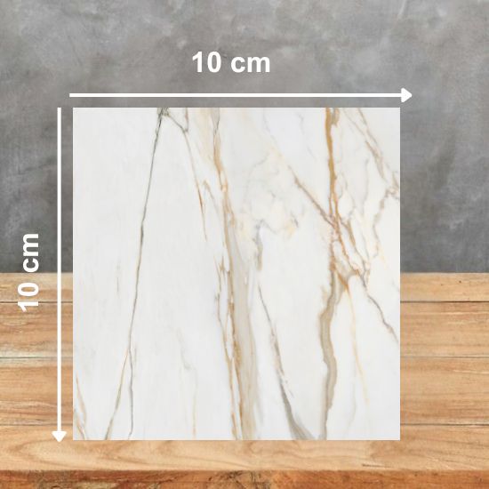 Muestra 10x10 cm de Venux Calacatta Gold blanca con vetas doradas sobre fondo gris.