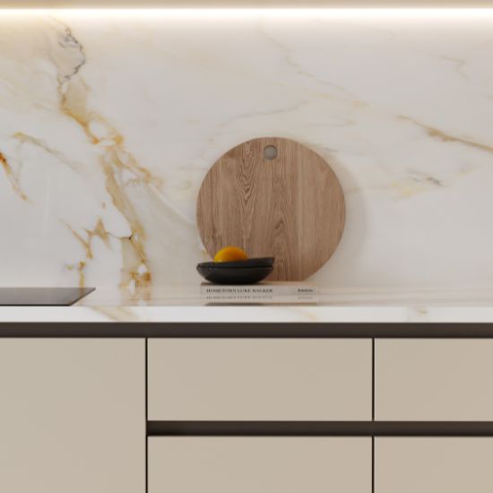Cocina moderna con encimera y salpicadero Venux Calacatta Gold blanca veteada, grifo negro y utensilios en ambiente elegante.