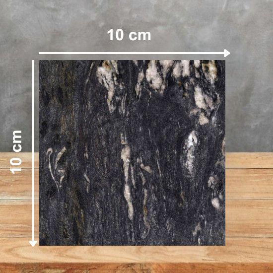 Muestra 10 x 10 cm de Granito Cosmic Black, granito negro con vetas blancas y doradas sobre superficie de madera
