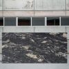 Losa completa pulida de Granito Cosmic Black con vetas blancas y doradas en movimiento espectacular
