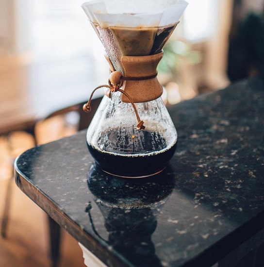 Cafetera sobre encimera de Granito Cosmic Black, granito negro con vetas blancas y doradas de alto brillo