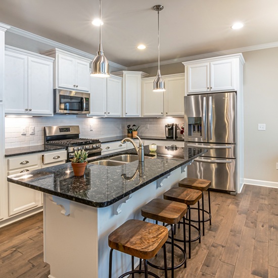 AlternativoIsla de cocina moderna con encimera de Granito Cosmic Black, granito negro con vetas blancas, muebles blancos y taburetes de madera