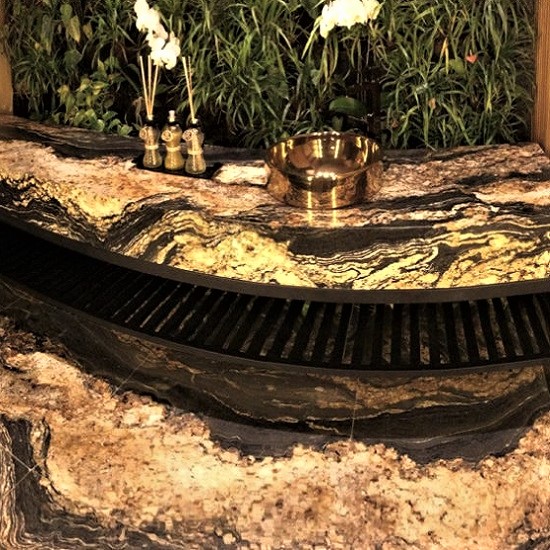 arra curva o mueble auxiliar en Granito Black Taurus con cuenco dorado y decoración