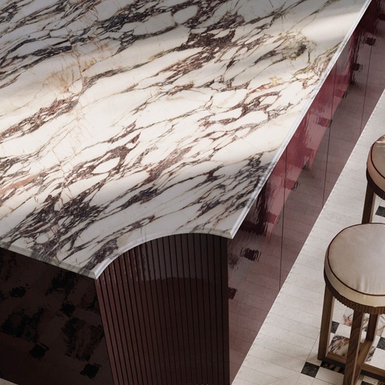 Detalle superior de isla curva en Sapienstone Fior di Viola 4D con veta pasante, mostrando el canto y las vetas continuas en mármol efecto