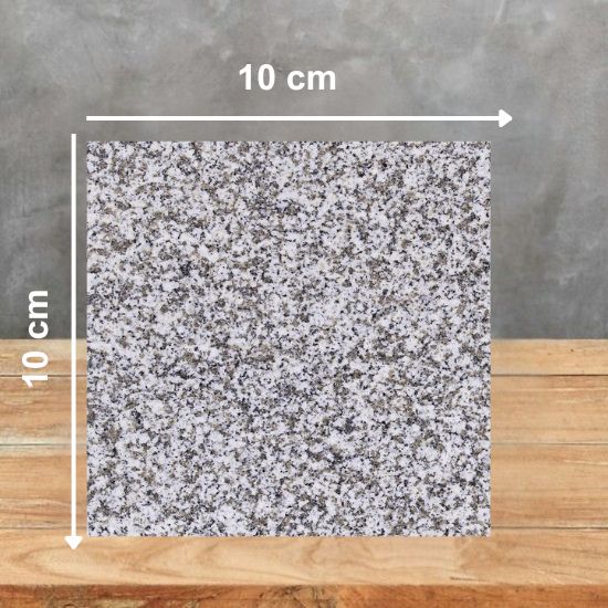 Muestra 10 x 10 cm de Granito Blanquino sobre superficie de madera