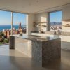 Isla de cocina moderna en Granito Blanquino con vistas panorámicas al mar y ciudad
