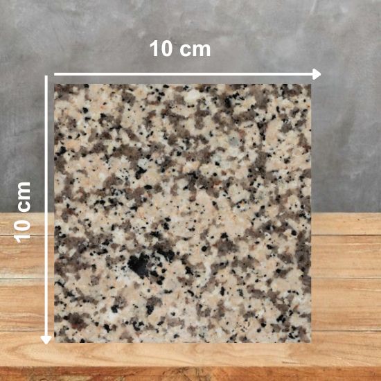 Muestra 10 x 10 cm de Granito Crema Camelia sobre superficie de madera