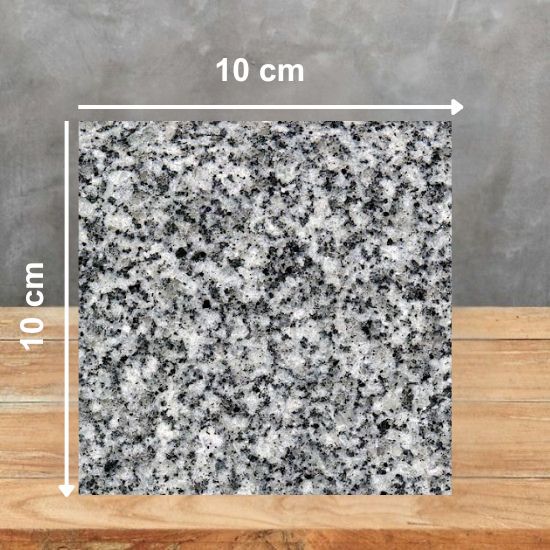 Muestra 10 x 10 cm de Granito Gris Quintana sobre superficie de madera
