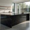 Isla de cocina con encimera cuarcita Naturamia Hydra negra y ventanales