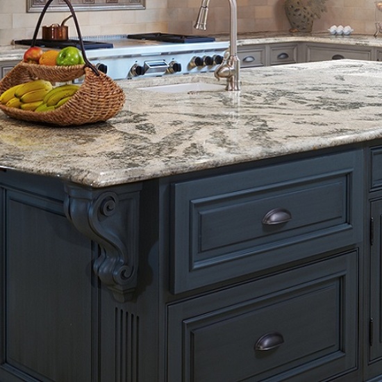Isla de cocina en cuarzo gris con canto pecho de paloma y armarios azul oscuro