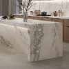 Isla de cocina iluminada en porcelánico Techlam Delta con vetas grises visibles