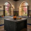 Isla de cocina exterior en porcelánico Techlam Pierre Bleue negro en patio andaluz