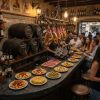 Barra de bar en porcelánico Techlam Pierre Bleue negro con jamones y tapas