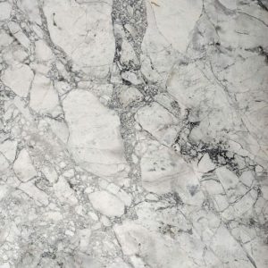 Cuarcita Terra Oriella / Superwhite detalle textura blanca con vetas negras y grises fragmentadas