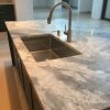 Isla de cocina con fregadero undermount sobre cuarcita Terra Oriella / Superwhite