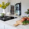 Encimera cuarcita Terra Paraná en cocina moderna blanca con flores amarillas