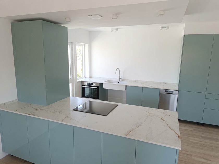 Modern kitchen with large white porcelain countertop and sage green cabinets installed in Benalmádena Málaga