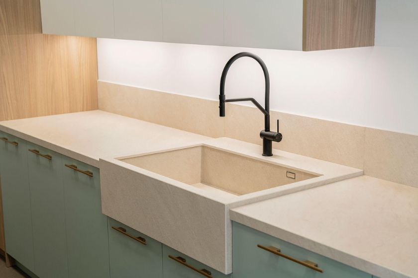 Encimera Ceratop Duna beige con fregadero integrado y grifo negro en cocina moderna