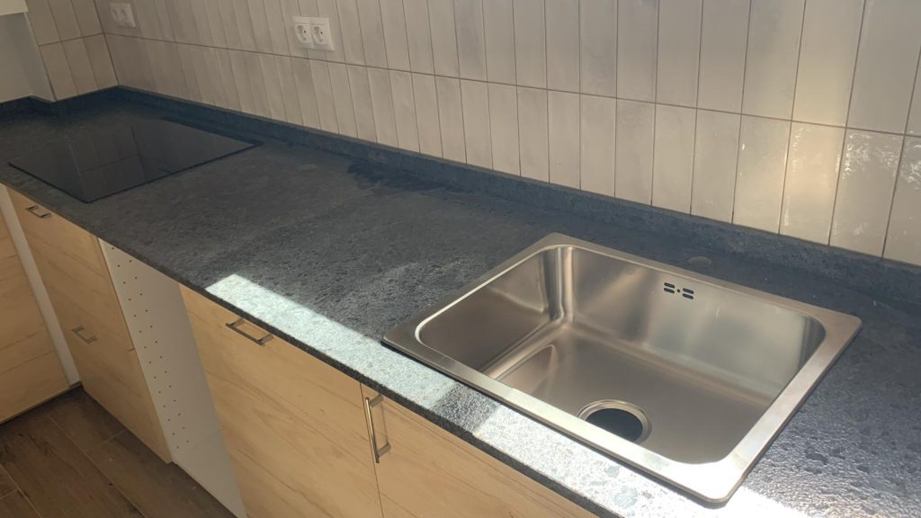 Stainless steel sink integrated in Granito Steel Gray countertop in Rincón de la Victoria kitchen