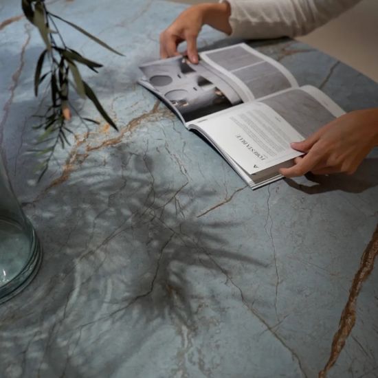 Mesa con encimera Ascale Foresta Blue y revista abierta