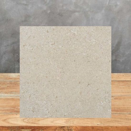 Muestra Dekton Avorio sobre madera con fondo de hormigón