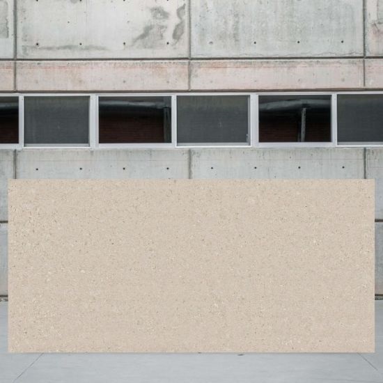 Placa grande de Dekton Avorio frente a edificio de hormigón