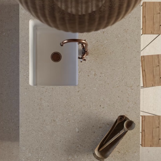 Detalle de fregadero integrado en encimera Dekton Avorio con grifo dorado