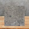 Muestra Dekton Ceppo sobre madera con fondo de hormigón