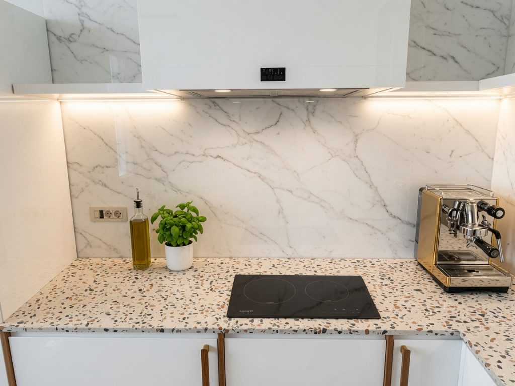 Quartz terrazzo-effect commercial kitchen worktop with marble-look splashback