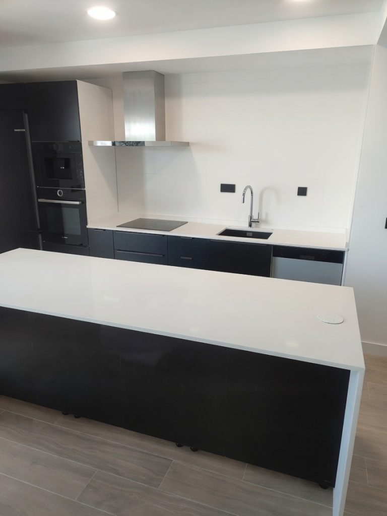 Pure white quartz kitchen island and worktops installed in a Marbella renovation