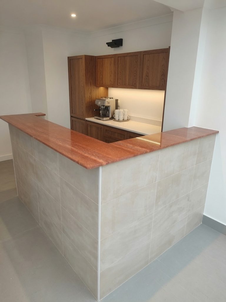 Red travertine bar countertop installed in a Costa del Sol renovation by Encimeras Málaga