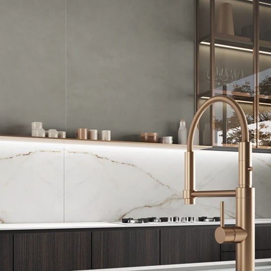 Revestimiento de pared Ascale Verso Gold con grifería dorada en cocina